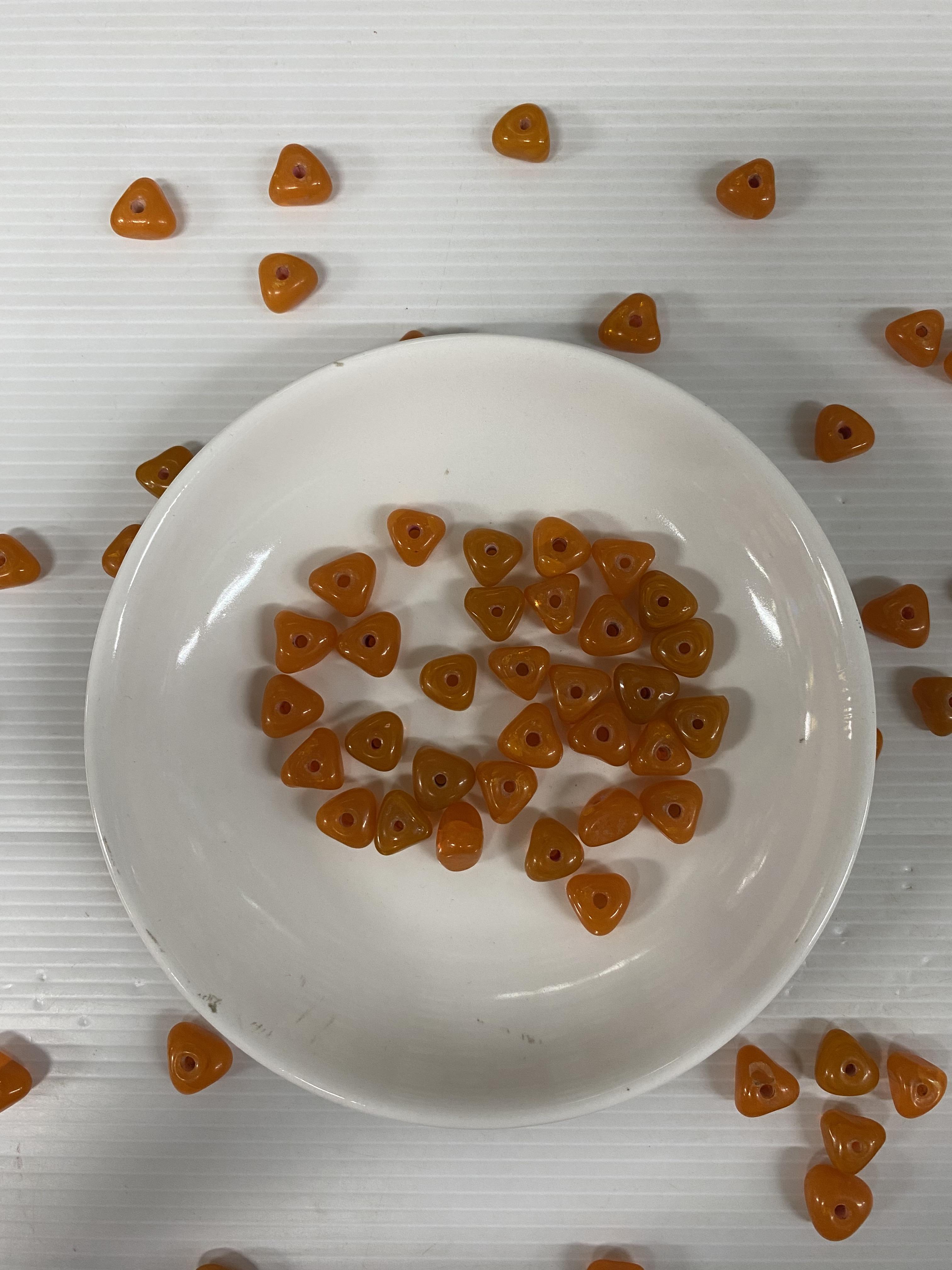 ลูกปัดแก้วอินเดียทรงสามเหลี่ยมสีส้มขุ่น 12 มิล 100 กรัม 200 บาท