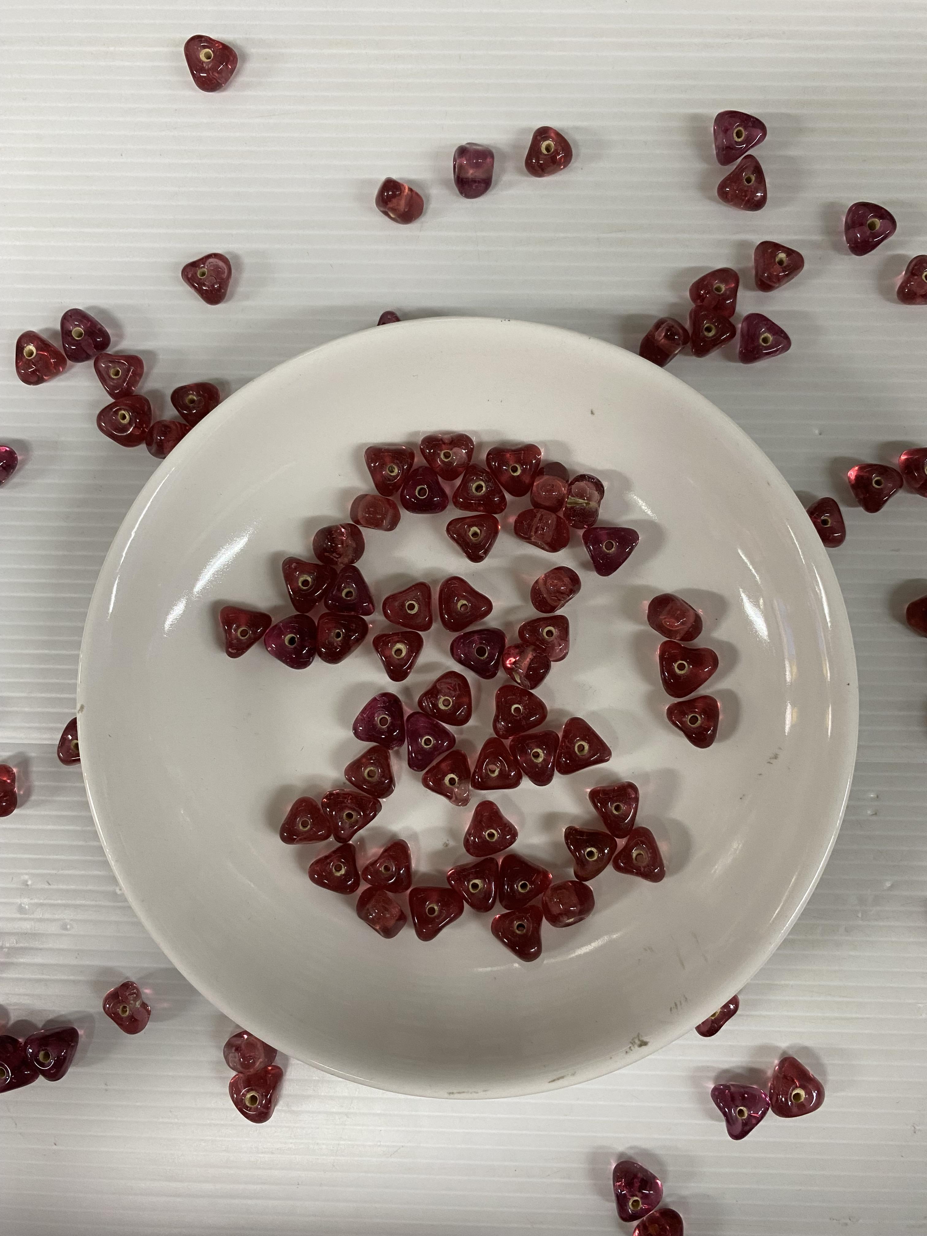 ลูกปัดแก้วอินเดียสอดไส้ สีชมพูลิ้นจี่ทรงสามเหลี่ยม10มิล100กรัม200บาท