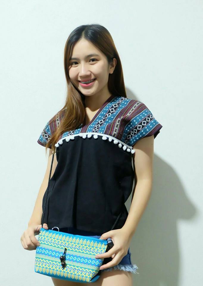 เสื้อนากา เสื้อผ้าพื้นเมือง เสื้อผ้าฝ้ายล้านนา คอวี โทนสีฟ้า ตัวเสื้อสีดำ แต่งปอม ลายผ้าพื้นเมืองสวยๆ